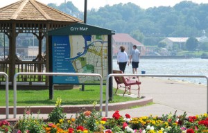 A couple strolls along the Grand River waterfront in Grand Haven, Mich., near its convergence with Lake Michigan. Local officials said they have taken steps to protect water quality in the river and are preparing to meet with consultants to discuss ways to make the area more resilient as the planet warms. In many conservative strongholds, words such as "sustainability" or "resilience" are used rather than "global warming" and "climate change." (AP photo by John Flesher)