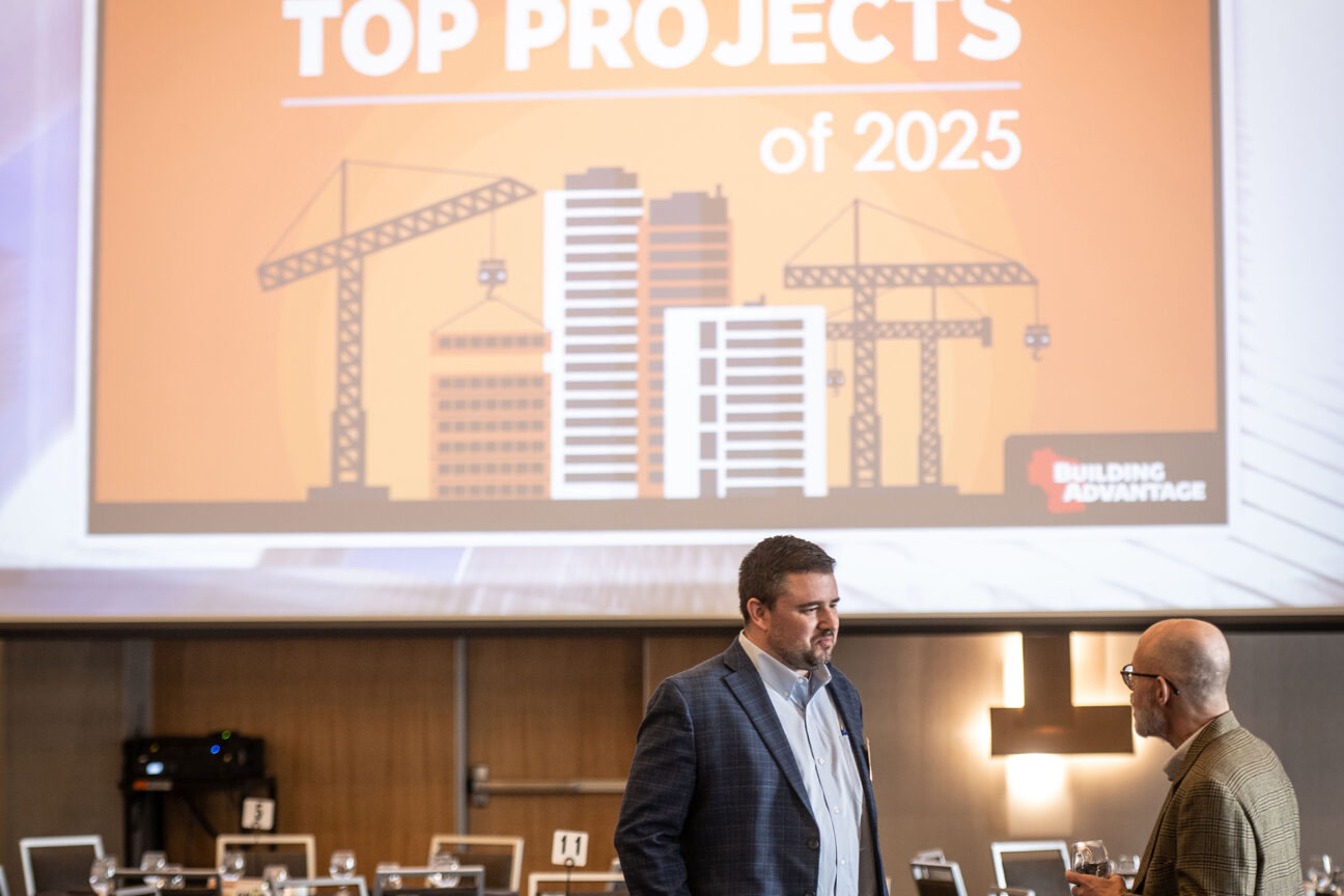 Rob Bergmann of Scherrer Construction and Scott Allen of eXp Realty talk as the Top Projects logo is projected on a large screen behind them. (Photos by Kevin Harnack)